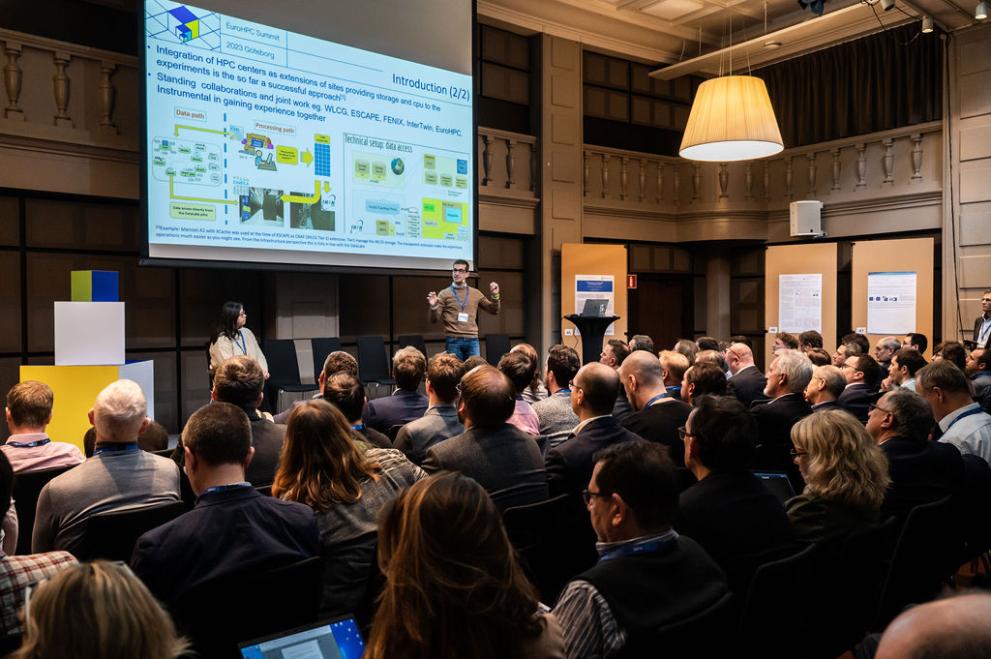 A photo of an audience from behind, watching a presenter and a powerpoint presentation